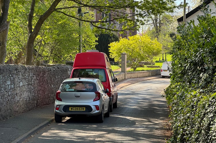 The two vehicles parked a narrow section of Church Street, Crediton, which are causing an obstruction.  AQ 9702
