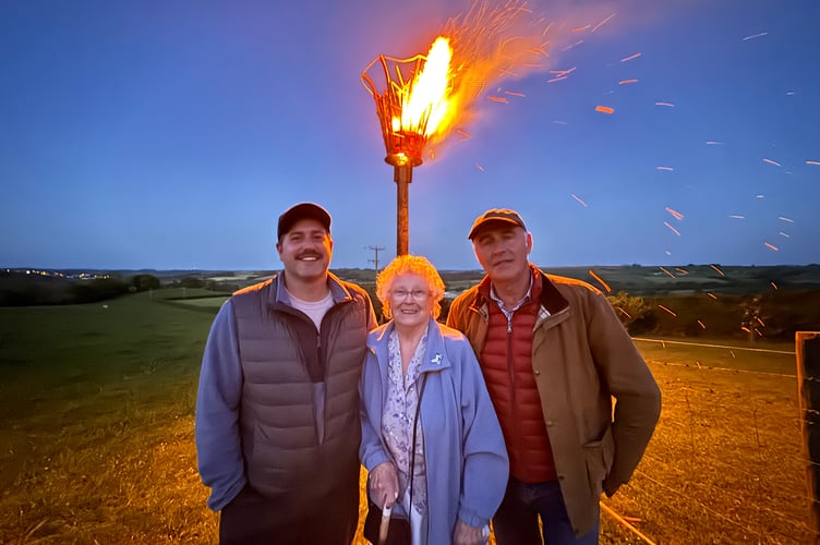 Beryl Meier after lighting the Beacon at Coldridge with Robert Burrow and Christopher Burrow, left and right. AQ 0917
