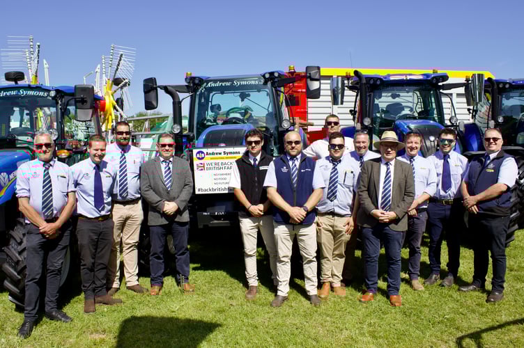 Andrew Symons, wearing hat, with son Scott to his left with employees