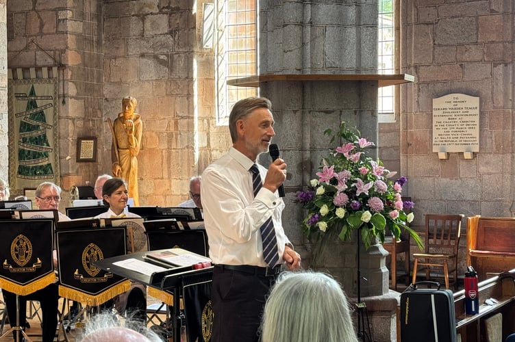 Crediton Town Band Musical Director Iorwerth Pugh talks prior to another tune from the band. AQ 2174
