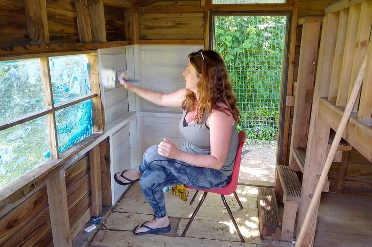 Painting the inside of the playhouse in the school grounds.
