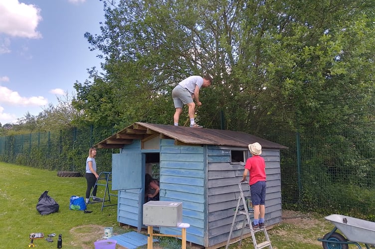 Sprucing up the playhouse at Cheriton Fitzpaine Primary School.

