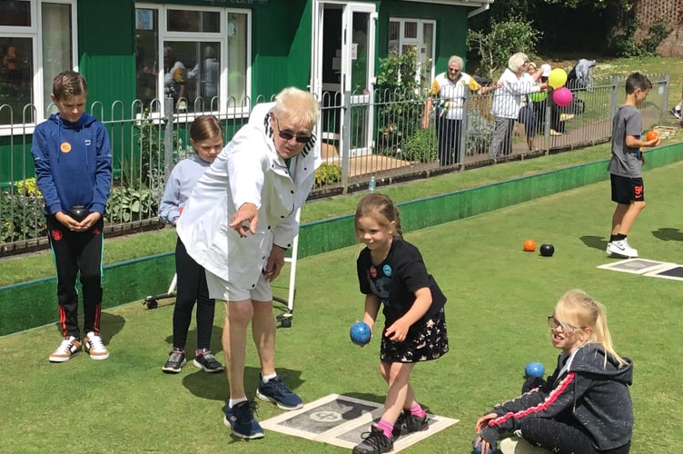Learning how to bowl at Crediton Bowling Club open day.