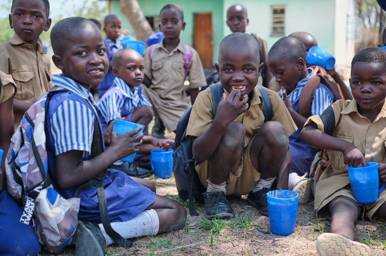 Children eating Mary's Meals porridge at school in Zimbabwe.
