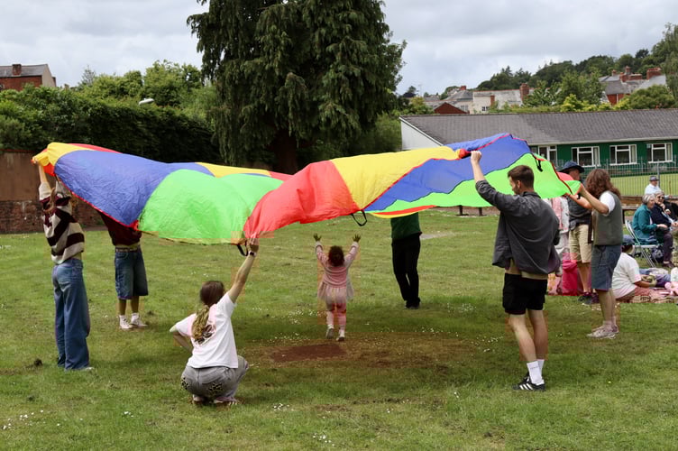 Children enjoyed playing with a colourful parachute