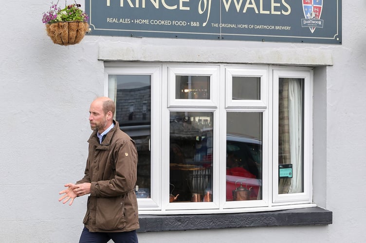 The Prince of Wales walks past the Prince of Wales pub on a visit to Princetown today.