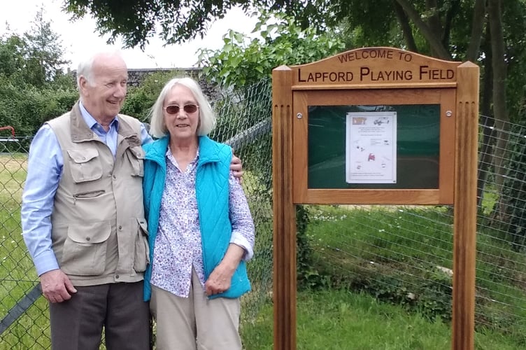 Derek Parrot, who made the sign, pictured with his wife Janice beside it.