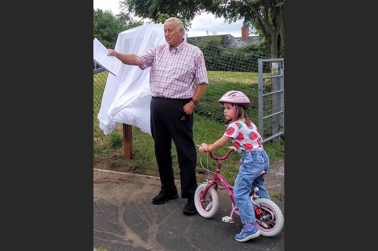 Roy Andrews, Lapford Playing Field chairman and his granddaughter, Aurelia, beside the sign before it was unveiled.