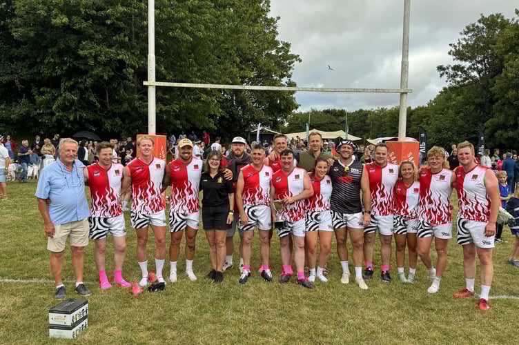 Eddie Trick, Crediton RFC Board Member, left, and Liz Goodman, Crediton RFC Chair, fifth left, presented the FDS Warriors with the winner’s trophy with Jack Yeandle, fifth right.  AQ 6033
