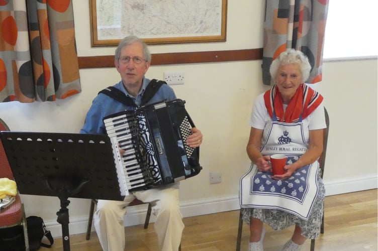 John Wilson on his accordion with Brenda Fowler, current chairman