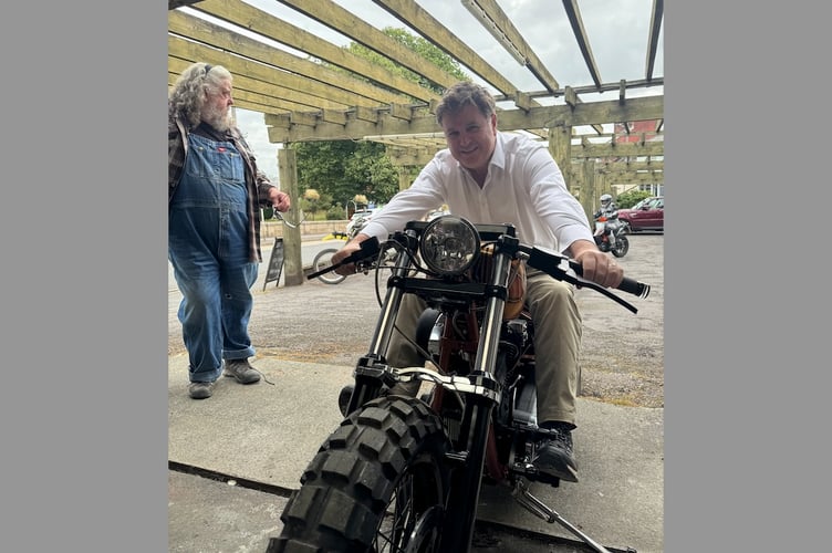 Mel Stride aboard a motorbike during his recent visit to Union Road Moto Velo in Crediton with Neil Paterson, business owner, left.
