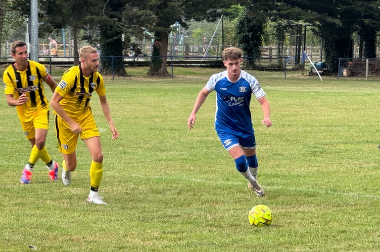 A Crediton United player in possession during the Dave Lee Testimonial game. AQ 7113