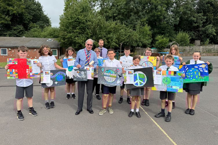 Copplestone pupils show off their peace posters with Eric Parkes from Crediton Lions and teacher Mr Wyatt. AQ 6893