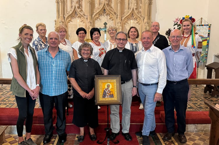 At the dedication of the icon at St Swithun’s Church, Rev Sandra Collier and Rev Matthew Tregenza, centre with churchwardens Victoria Leeming, left, and John Lee, fifth left, with Eddie Sherwood, second left, and Peter Gilks, right with back, the Ukrainian Singers and James Cookson.  AQ 6729
