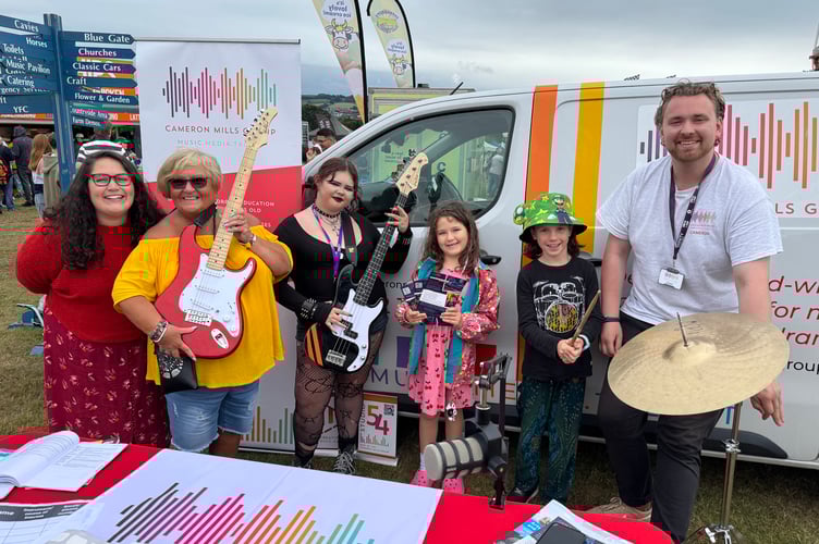 Cameron Mills, right, of Cameron Mills Group, talked about services offered by the business and some young people played music on the Mid Devon Show music stage. AQ 7634