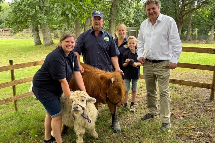 Mel Stride MP, right, with Kevin and Becky and Nicholas (9) with a cow and calf at Lindfield Day Opportunities. AQ 7043