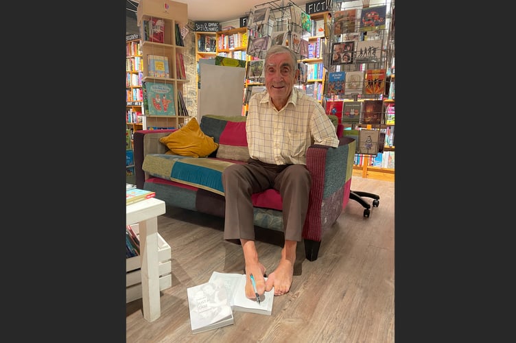 Frank signing a copy of his autobiography at The Bookery in August 2022.  AQ 3834
