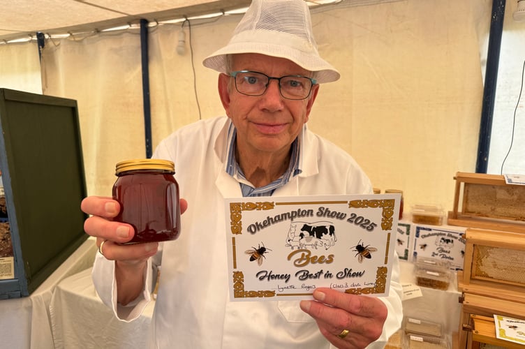 National Honey Judge Jack Mummery of West Buckland with the Best in Show Honey which was exhibited by Lynette Rogers from Okehampton.  AQ 9975
