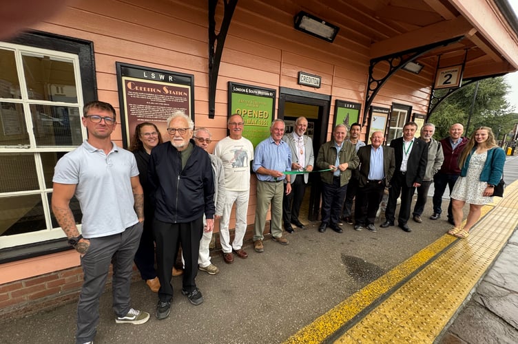 The Mayor of Crediton, centre, about to cut a ribbon to officially reopen the waiting room at Crediton Railway Station which now has historic railway photographs and panels about the history of the railway in the town and area.  AQ 0826
