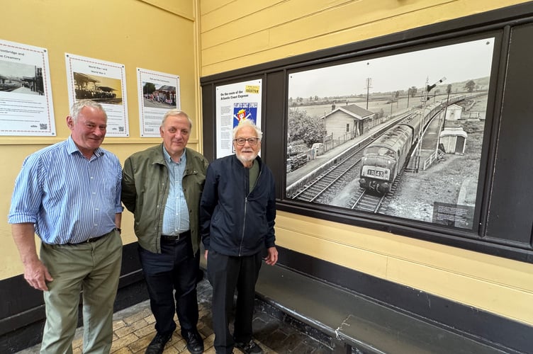 Admiring the photo in the display taken by Roger Joanes, right, of a train travelling through Newton St Cyres Station on May 21, 1966 are Tony Hill, left and Richard Burningham, centre. AQ 0847
