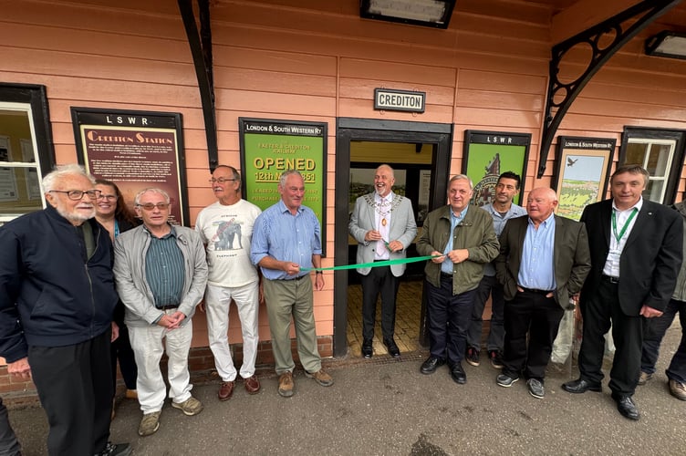 The Mayor of Crediton, centre, about to cut a ribbon to officially reopen the waiting room at Crediton Railway Station which now has historic railway photographs and panels about the history of the railway in the town and area. AQ 0822