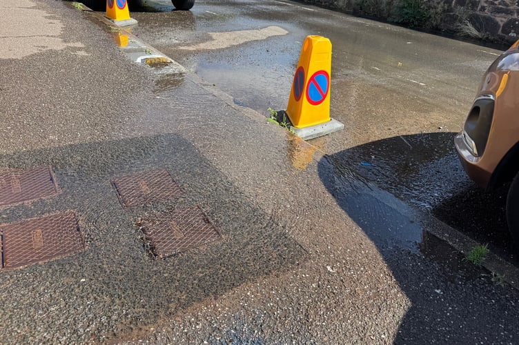 The water leak from a pavement in Belle Parade, Crediton. AQ 1173