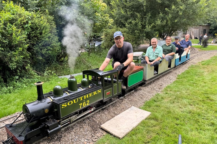 Alistair Hall driving steam engine Lyn, sat in front of Lapford Mill owner Alex and other passengers. AQ 8068
