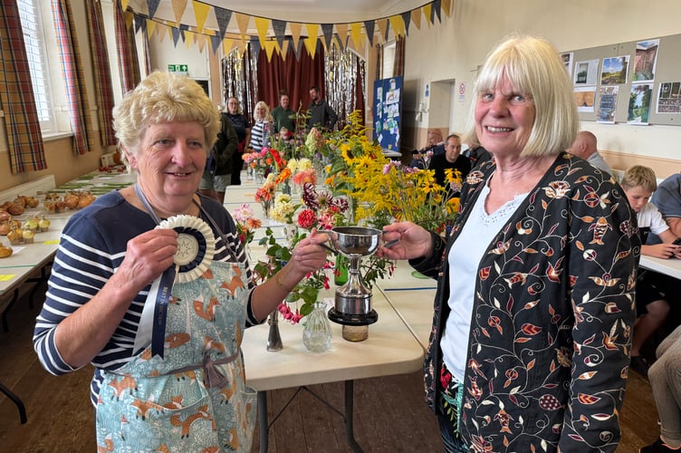Margaret Harris, left, received the Cookery Cup and won the Best in Section for her Swiss Roll, presented by Erica Eden. AQ 1675