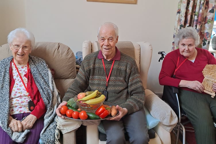 Residents of Hillbrow with harvest fruit and veg and a wheat sheaf loaf.
