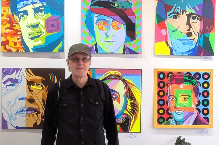 Colin Sundborg in front of his paintings.
