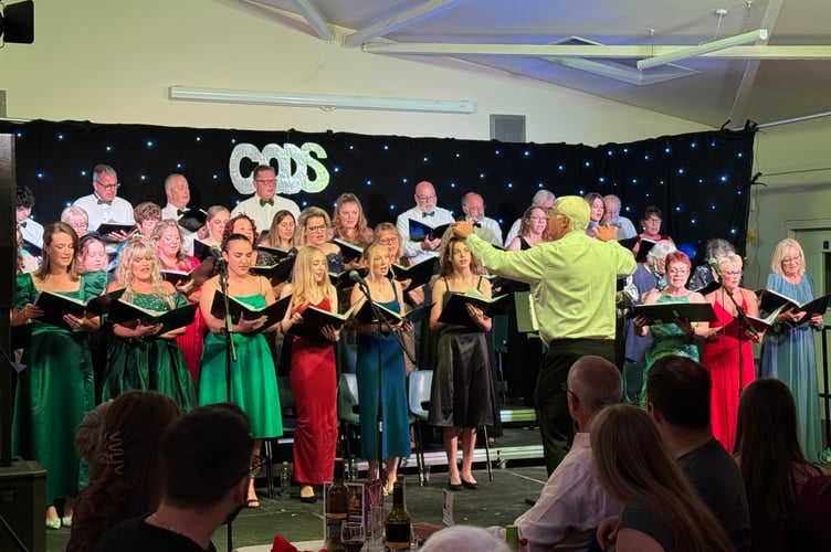 Singers on stage with Musical Director Mike Canning for CODS Sounds of the 80’s evening.  AQ 3467

