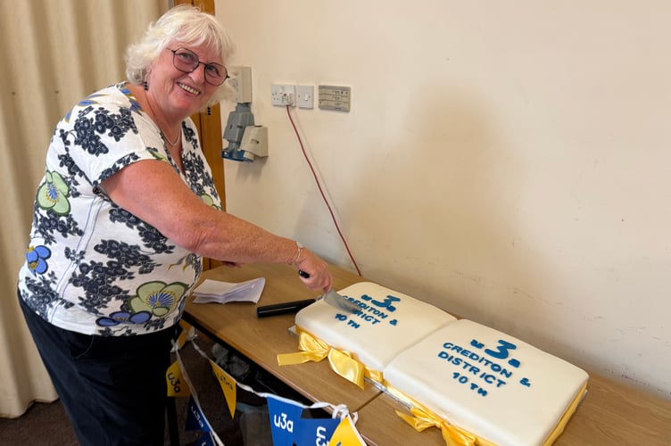 Crediton and District u3a first chair Jane Innes cutting celebration cakes to mark the 10th anniversary.  AQ 3157
