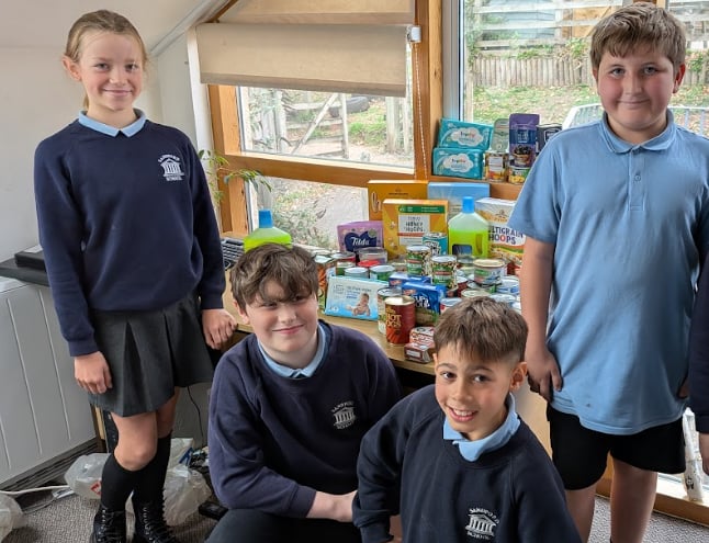 Some of the children from Sandford School with some of the donations for Crediton Foodbank.
