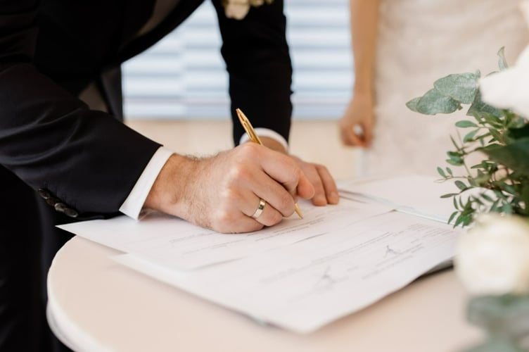 A couple signing official marriage documents.
