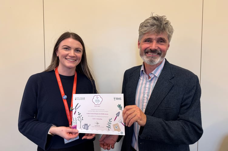 Crediton Town Council Assistant Clerk Emma Anderson presented the Level 5 It’s Your Neighbourhood Outstanding certificate to People’s Park Wildlife Area representative Cllr Giles Fawssett. AQ 7199