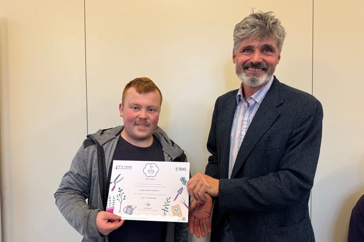 Crediton Town Councillor Giles Fawssett, right, presents the Level 5 It’s Your Neighbourhood Outstanding certificate to a representative from Crediton Station Tearooms. AQ 7189