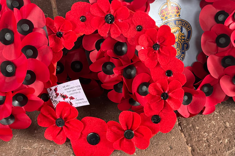 The Hayward’s Primary School hand-made Poppy wreath on Crediton War Memorial in 2025. AQ 7801