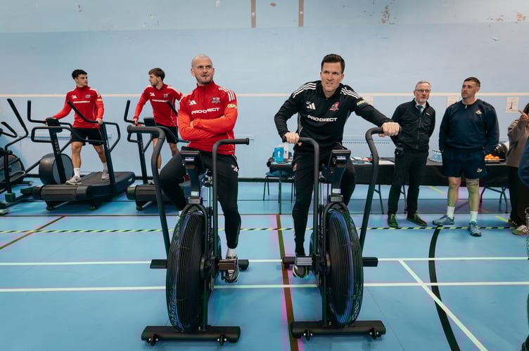 Exeter City FC team captain Pierce Sweeney and manager Gary Caldwell, centre, with other team players and officers at HMP Exeter.