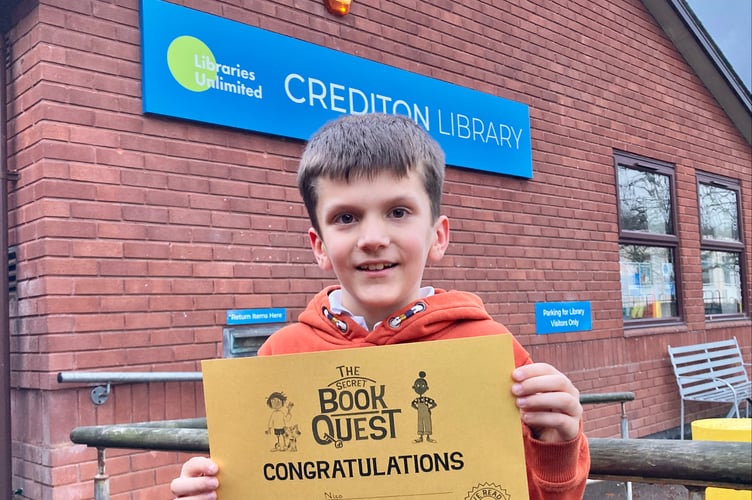 Nico with his gold Secret Book Quest certificate outside Crediton Library