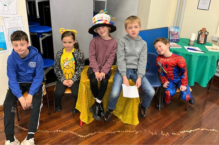 Pupils in own clothes and costumes with the penny mile below
