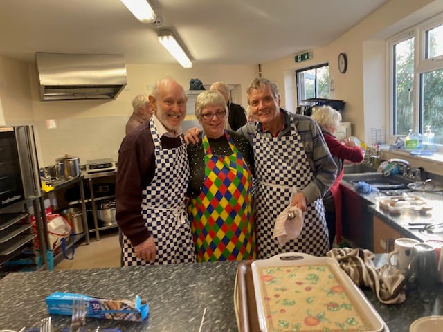 Jonathan Berg, Denise Kingdon and Roy Clayton serving in the kitchen.