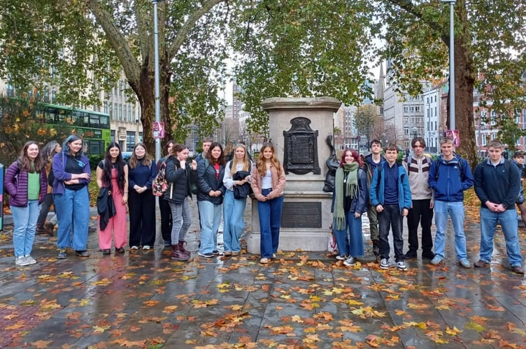 The students standing next to the empty plinth where the statue of Edward Colston once stood