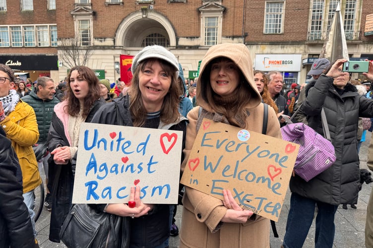 Two people with placards in the Exeter is for Everyone march. AQ 8749