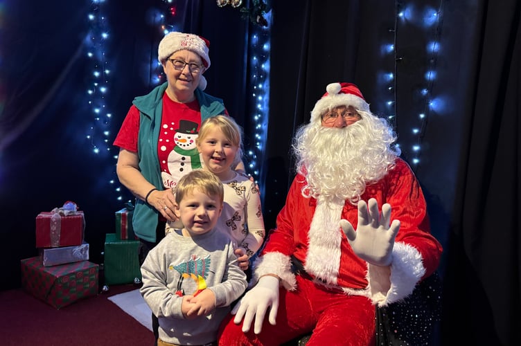 Father Christmas with his helper and two children, Phoebe Morgan (6) and Ollie Rundle (3) who visited him at Bow Christmas Market. AQ 8567
