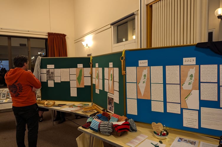 Looking at a display of information at the Voices for Gaza event.
