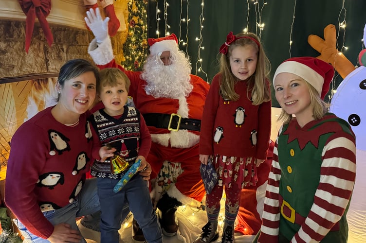 Father Christmas and his helper with a mum and two young visitors at Bow School’s Christmas Fair. AQ 9991
