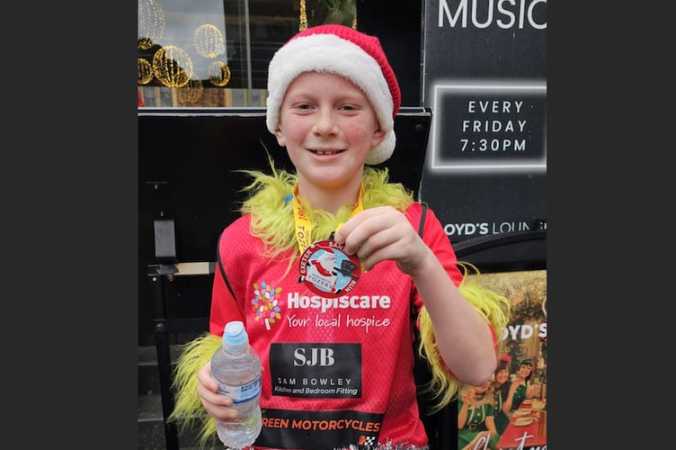 Harry with his medal after completing the Exeter Santa Run.
