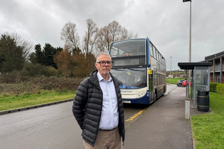 Councillor John Downes in front of a Stagecoach bus at the bus stop outside Redlands Surgery where there is one shelter, but none the other side. AQ 0237