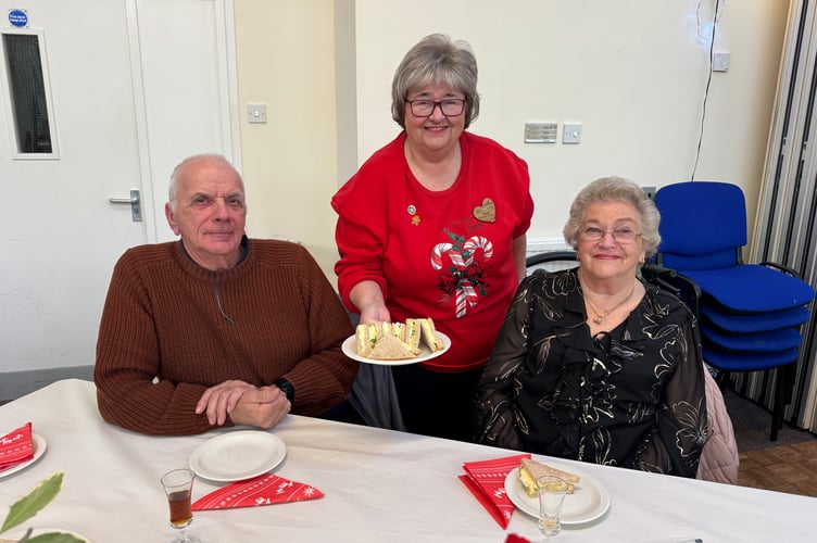 Hazel Evely, Morrisons Community Champion, serving sandwiches to guests at the Senior Citizens Christmas Tea Party. AQ 0531