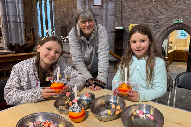 Church volunteer Liz Brookes-Hocking advised how to make the Christingles.  AQ 0639
